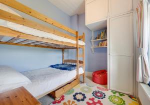 a bedroom with two bunk beds and a rug at Ynys Pandy in Llanfihangel-y-pennant