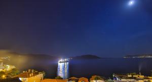 a boat in a large body of water at night at Hotel Sonne - Adults Only in Kaş