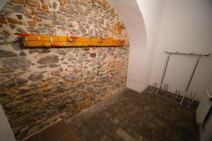 eine Steinmauer mit einem Holzregal an der Wand in der Unterkunft Apartmany 21 Třeboň in Třeboň