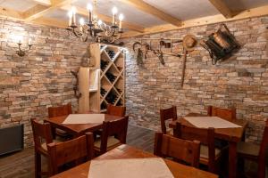 a restaurant with wooden tables and chairs and a brick wall at Glamping Happiness with Sauna and Natural Pool in Ribnica