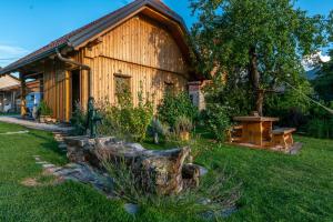 a wooden cabin with a log in the yard at Glamping Happiness with Sauna and Natural Pool in Ribnica
