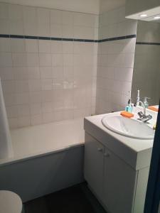 een badkamer met een wastafel, een bad en een spiegel bij Studio au calme dans résidence Gauguin pour location courte durée et étudiants in Gières