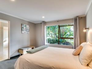 ein Schlafzimmer mit einem großen Bett und einem Fenster in der Unterkunft Tango10 Accommodation - Best views in Hawke's Bay in Tangoio