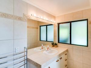 baño con lavabo y 2 ventanas en Tango10 Accommodation - Best views in Hawke's Bay en Tangoio