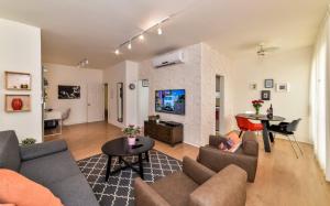 a living room with a couch and a table at SOKOLOV Vacation Boutique Apartments by the sea in nahariya in Nahariyya