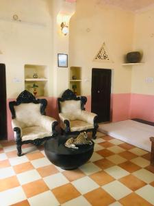 BALARWA HAVELI في جودبور: غرفة معيشة مع كرسيين وطاولة