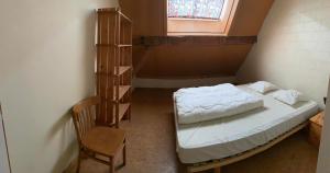 Cette petite chambre comprend un lit et une chaise. dans l'établissement Ferme Leclercqz, à Le Mesnil