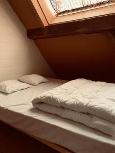 Ce lit se trouve dans un dortoir doté d'une fenêtre. dans l'établissement Ferme Leclercqz, à Le Mesnil