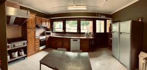 a kitchen with wooden cabinets and a white refrigerator at Ferme Leclercqz in Le Mesnil