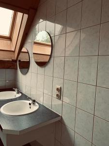 La salle de bains est pourvue de 2 lavabos et de 2 miroirs. dans l'établissement Ferme Leclercqz, à Le Mesnil