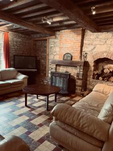 - un salon avec un canapé et une cheminée dans l'établissement Ferme Leclercqz, à Le Mesnil