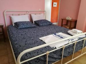 Una cama con marco de metal y almohadas. en A cosy 60 Sq. m. entire villa, en Pendéli