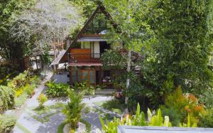 a house with a garden in front of it at Comfortable Wood House second floor and attic in Kuta Lombok