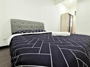 a bedroom with a bed with a black and white comforter at SKS Pavillion 1Bedroom High Floor @2pax By HAUZ CINTA in Johor Bahru