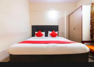a bedroom with a large bed with red pillows at Royal Guest Inn HSR Layout in Bengaluru