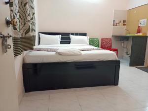 1 dormitorio con 1 cama grande con marco negro en Royal Guest Inn HSR Layout en Bangalore