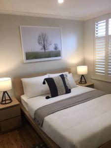 a bedroom with a large bed with two lamps at Modern Central China town Home - Free Carpark in Adelaide