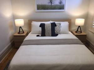 een slaapkamer met een groot wit bed met 2 lampen bij Modern Central China town Home - Free Carpark in Adelaide
