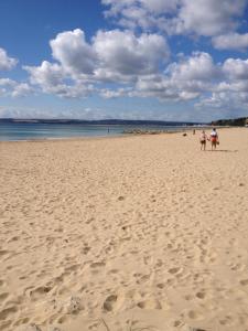 a person sitting on a beach on a sunny day at Grovefield Manor in Poole