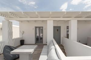 Barbarigos luxury spa apartments في ناوسا: فناء أبيض مع طاولة بيضاء وبيت أبيض