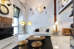 un soggiorno con divano e tavolo di AmazINN Places Gran Via Loft a Madrid
