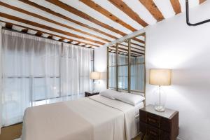 una camera con un letto bianco e una finestra di AmazINN Places Gran Via Loft a Madrid