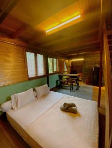 a bedroom with a large bed with a phone on it at Comfortable Wood House second floor and attic in Kuta Lombok