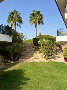 una escalera con palmeras en un patio en Vila Sol, Apartment 468, en Quarteira