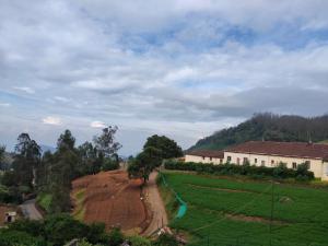 a view of a farm field and a house at Forest Gate in Ooty