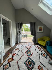 een zolderkamer met een tapijt op de vloer bij Lime Tree Cottage in Tillingham
