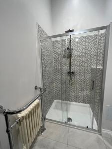 a shower with a glass door in a bathroom at Lime Tree Cottage in Tillingham