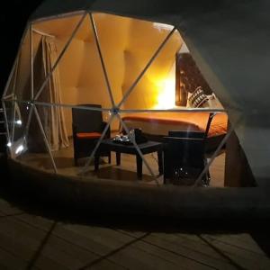 Zimmer mit einem Tisch und einem Bett in einem Zelt in der Unterkunft Rum Aranda camp & Jeep Tour in Wadi Rum