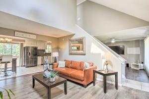 a living room with an orange couch and a kitchen at Waterbury Home Playground and Porch Swing in Waterbury