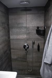 y baño con ducha con cabezal de ducha. en PullanHouse Laima - small and cosy lakeside holiday house, en Alūksne
