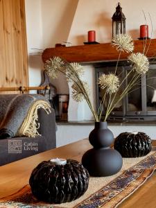 a table with a black vase with flowers on it at Centrally located cottage at Sjusjøen ski center in Ringsaker