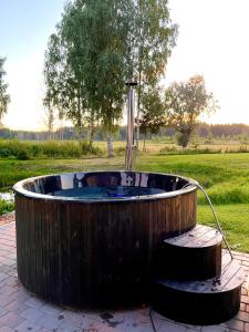 Valgesoo maakivivilla kuni 20-le kylalisele في Valgesoo: حوض استحمام ساخن خشبي مع نافورة مياه