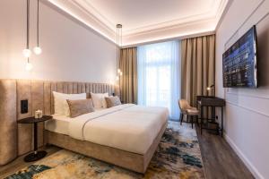 ウィーンにあるO11 Boutique Hotel Viennaの大型ベッド1台、テレビが備わる客室です。 +37枚の写真
