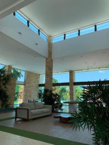 a living room with a couch and large windows at Suíte com varanda no iloa - sem enxoval in Barra de São Miguel