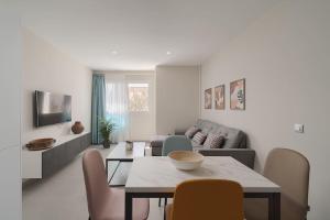 a living room with a table and chairs and a couch at Las Afortunadas , Playa Arinaga 1ºA in Arinaga