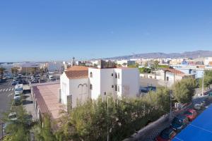 a white building in a city with a parking lot at Las Afortunadas , Playa Arinaga 1ºA in Arinaga