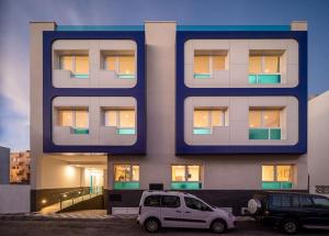 a white car parked in front of a building at Las Afortunadas , Playa Arinaga 1ºA in Arinaga