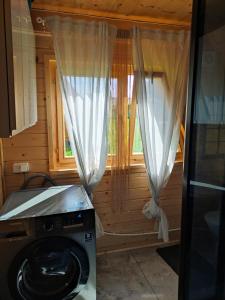 lavadora en una habitación con 2 ventanas en Good Time, en Sasino