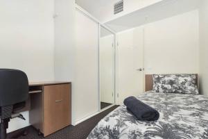 a bedroom with a bed and a desk and a computer at Light & Airy 3 Bd CBD Apt: BalconyTramWifi/Parking in Adelaide