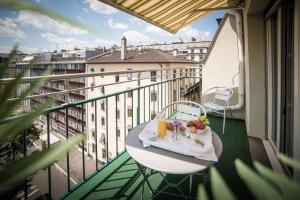 a balcony with a table with fruit and juice on it at Hotel Montana in Geneva