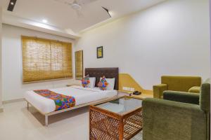 1 dormitorio con 1 cama y 2 sillas en FabHotel Aamantran & Banquet Halls, en Hyderabad