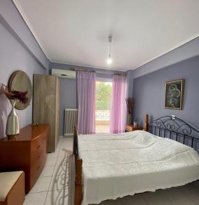 a bedroom with a bed and a window at Vivian’s apartment in Chalkida