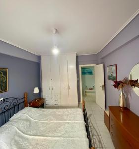 a bedroom with a bed and a dresser at Vivian’s apartment in Chalkida