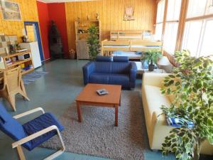 uma sala de estar com um sofá, cadeiras e uma mesa em Henseid Skole em Hennseid