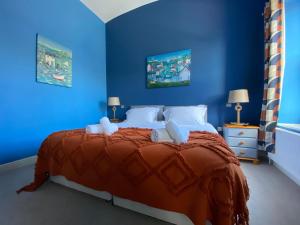 a blue bedroom with a large bed with blue walls at Harbour Inn in Amble