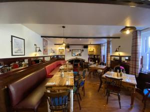 a restaurant with tables and chairs and a bar at Harbour Inn in Amble